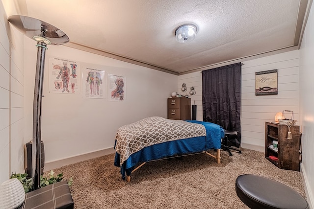 bedroom featuring carpet floors, a textured ceiling, and wooden walls