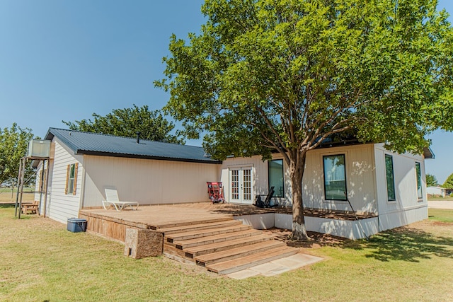 rear view of house with french doors, a yard, and a wooden deck