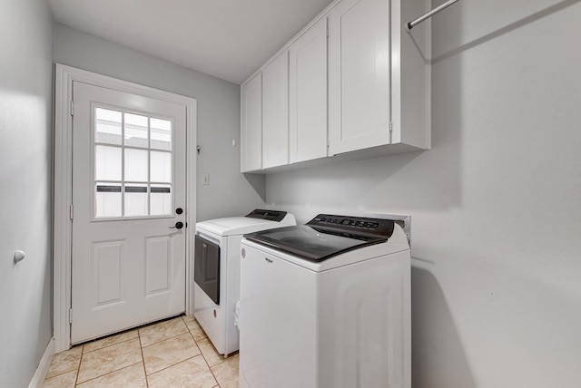 laundry area featuring baseboards, cabinet space, light tile patterned flooring, and independent washer and dryer