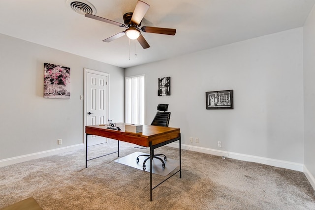 carpeted office space featuring baseboards, ceiling fan, and visible vents