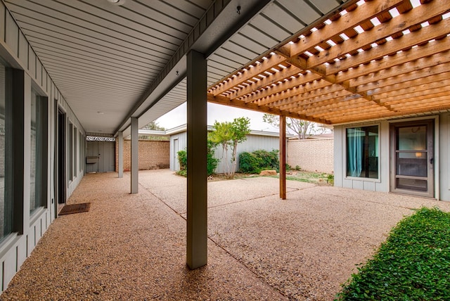 view of patio / terrace featuring a pergola, fence, and an outdoor structure