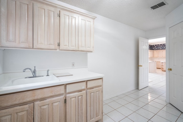 5500 Drexel, Midland, TX 79707 - kitchen featuring light countertops, light tile patterned floors, light brown cabinets, and a textured ceiling