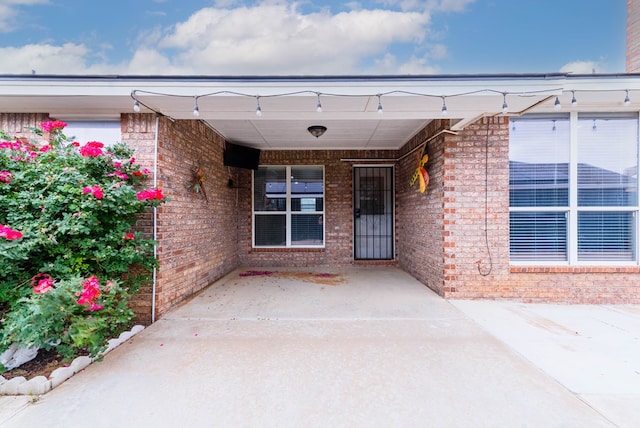 view of exterior entry featuring brick siding