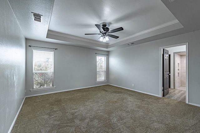 empty room featuring crown molding, a raised ceiling, ceiling fan, and carpet flooring