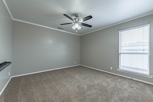carpeted spare room with crown molding, a ceiling fan, baseboards, and visible vents