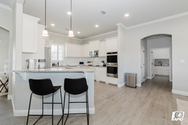 kitchen with light stone countertops, decorative backsplash, white cabinets, and stainless steel appliances