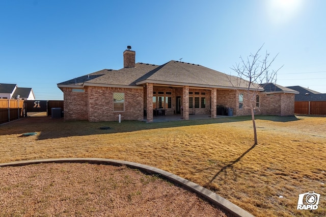 rear view of property with a yard, central AC, and a patio area