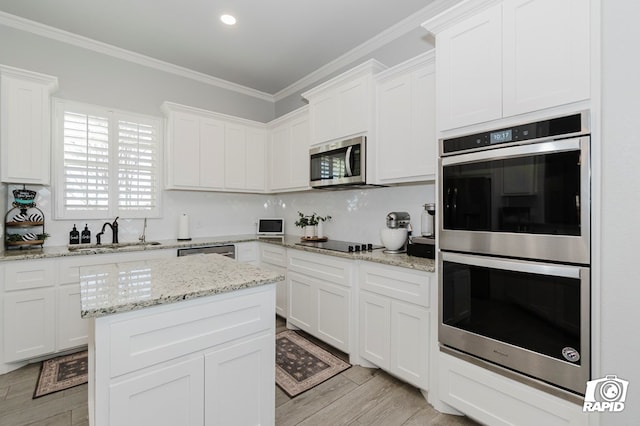 kitchen with crown molding, white cabinetry, sink, and appliances with stainless steel finishes