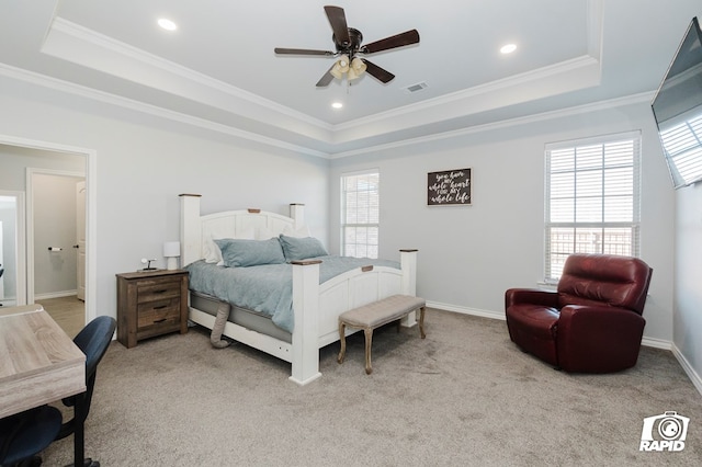 carpeted bedroom with ceiling fan, ensuite bathroom, crown molding, and a tray ceiling