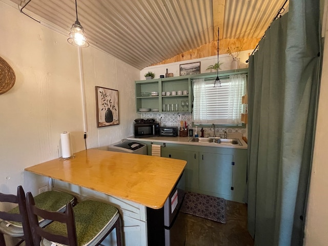 kitchen featuring decorative light fixtures, lofted ceiling, light countertops, green cabinets, and a sink