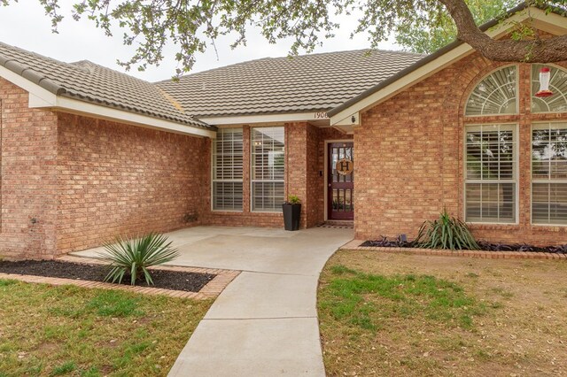 1906 Hereford Blvd, Midland, TX 79707 - property entrance with brick siding, a patio area, and a tiled roof