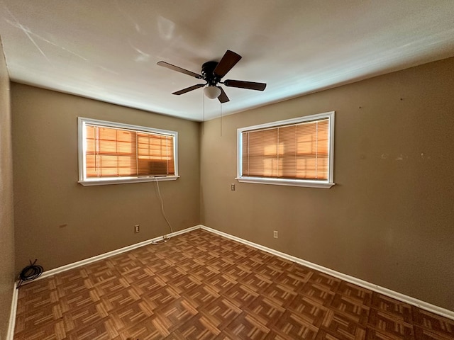 empty room with baseboards and a ceiling fan