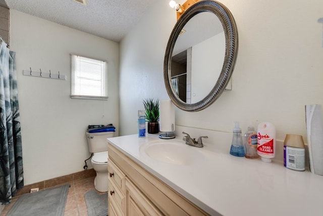 bathroom featuring tile patterned floors, vanity, a textured ceiling, and toilet