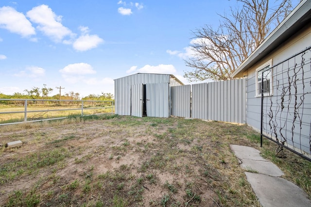 view of yard with a fenced backyard, a storage shed, and an outdoor structure