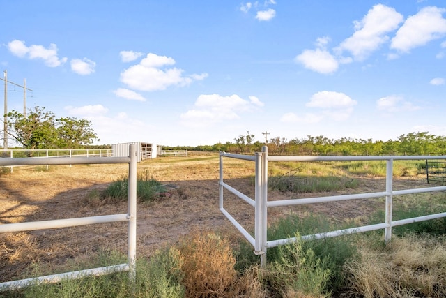 view of gate with a rural view and fence