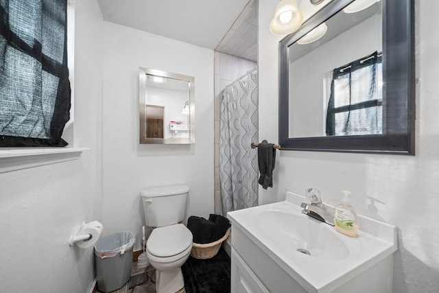 full bathroom featuring a shower with shower curtain, toilet, and vanity