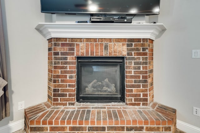 room details featuring a fireplace and baseboards