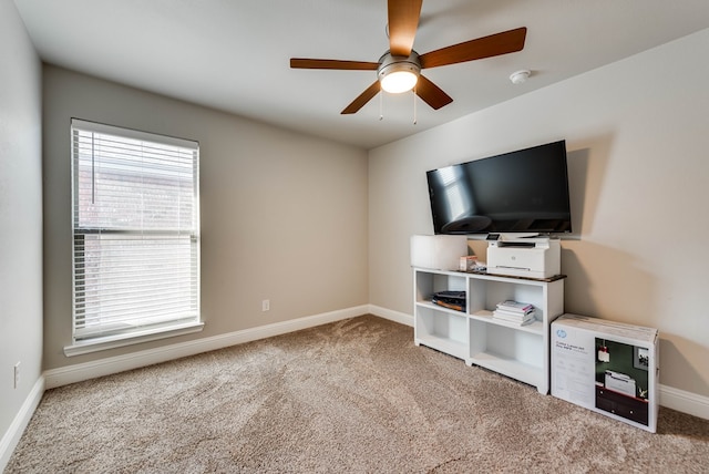 unfurnished living room with carpet floors, baseboards, and ceiling fan