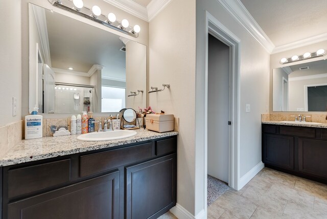 bathroom featuring two vanities, crown molding, a sink, and baseboards