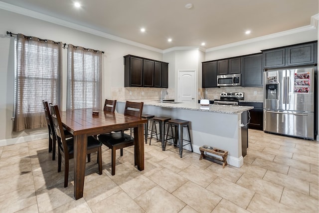 kitchen with a peninsula, tasteful backsplash, crown molding, and stainless steel appliances
