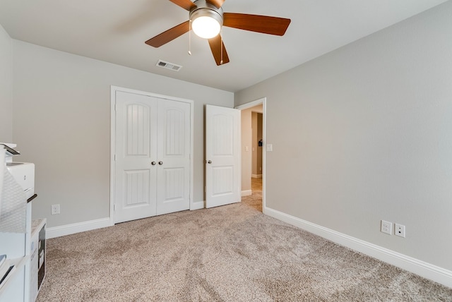 unfurnished bedroom with a closet, baseboards, carpet flooring, a ceiling fan, and visible vents