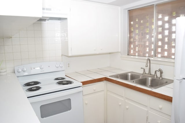 kitchen with white appliances, a sink, and white cabinetry