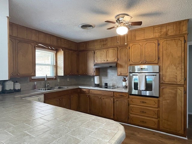 4500 El Paso, Snyder, TX 79549 - kitchen featuring oven, black electric cooktop, a textured ceiling, brown cabinets, and ceiling fan
