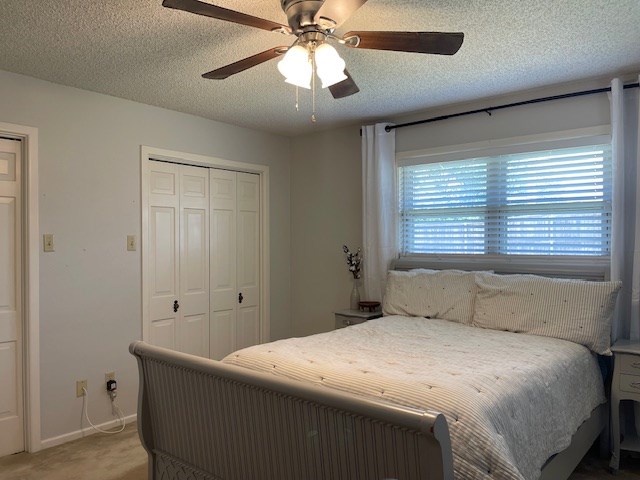 4500 El Paso, Snyder, TX 79549 - bedroom featuring a closet, light carpet, a ceiling fan, and a textured ceiling