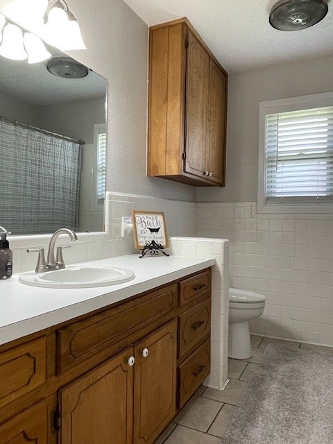 4500 El Paso, Snyder, TX 79549 - full bathroom with tile patterned floors, tile walls, vanity, a wainscoted wall, and a shower with shower curtain