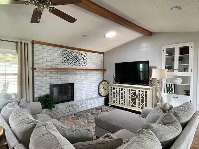 4500 El Paso, Snyder, TX 79549 - living area with ceiling fan, wood finished floors, a fireplace, and a textured ceiling