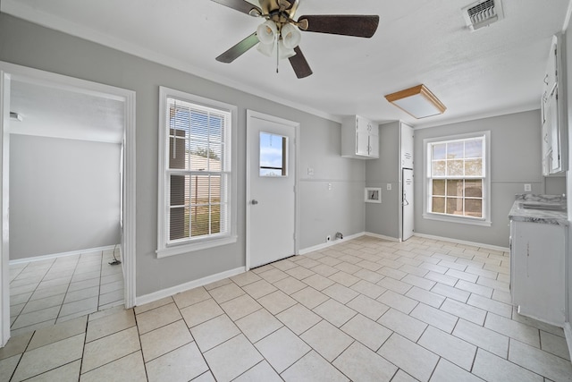 1309 Marijo, Big Spring, TX 79720 - kitchen with light countertops, crown molding, white cabinets, a ceiling fan, and light tile patterned flooring