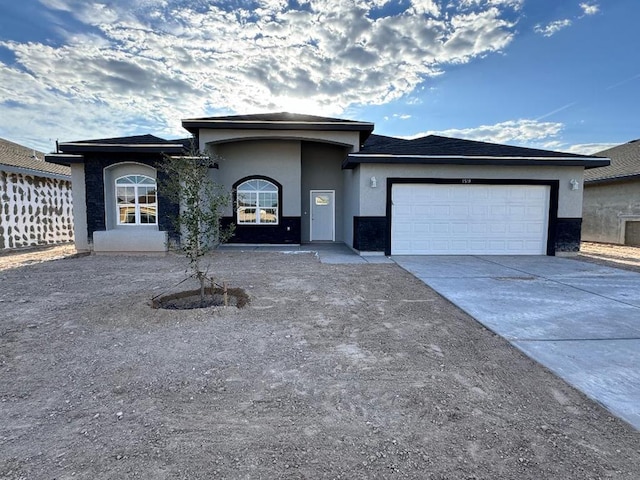 2101 S Iowa St, Pecos, TX 79772 - prairie-style house featuring an attached garage, stucco siding, and driveway