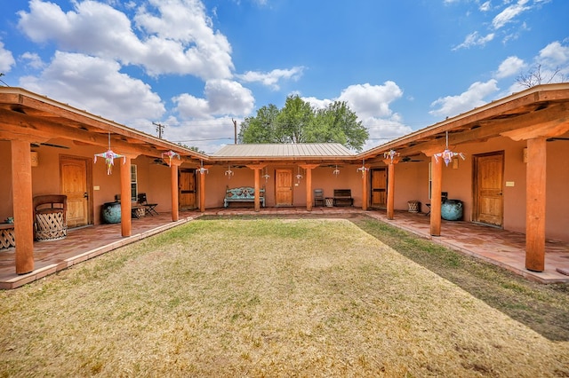 2309 W Golf Course Rd, Midland, TX 79701 - back of property with stucco siding, a ceiling fan, and a lawn