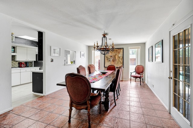 2309 W Golf Course Rd, Midland, TX 79701 - dining space featuring an inviting chandelier, light tile patterned flooring, and baseboards