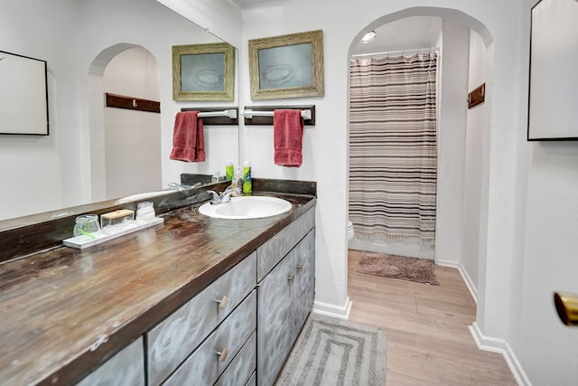 2309 W Golf Course Rd, Midland, TX 79701 - bathroom with a shower with shower curtain, baseboards, toilet, wood finished floors, and vanity