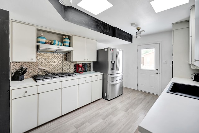 2309 W Golf Course Rd, Midland, TX 79701 - kitchen featuring decorative backsplash, a sink, light countertops, gas cooktop, and stainless steel fridge with ice dispenser