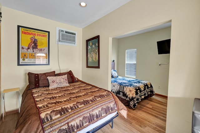 2309 W Golf Course Rd, Midland, TX 79701 - bedroom featuring baseboards, recessed lighting, wood finished floors, and a wall mounted AC