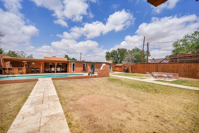 2309 W Golf Course Rd, Midland, TX 79701 - rear view of property featuring fence, a yard, a fenced in pool, and a patio area