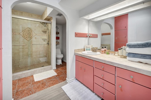 2309 W Golf Course Rd, Midland, TX 79701 - full bath with vanity, toilet, a stall shower, visible vents, and wood finished floors