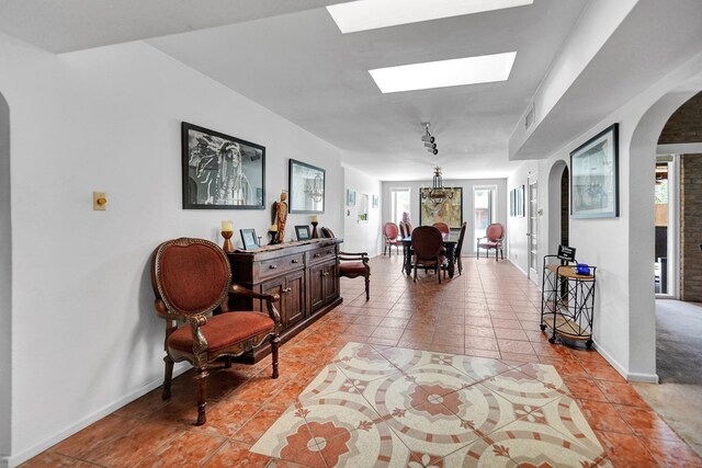 2309 W Golf Course Rd, Midland, TX 79701 - hall with arched walkways, a skylight, light tile patterned floors, baseboards, and visible vents