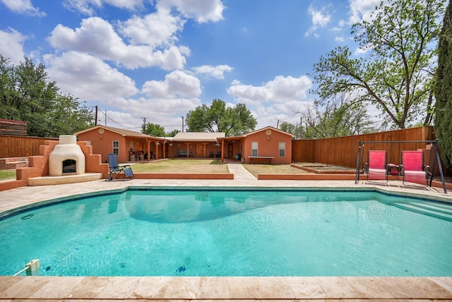2309 W Golf Course Rd, Midland, TX 79701 - view of pool featuring a fenced in pool, a patio area, exterior fireplace, and a fenced backyard