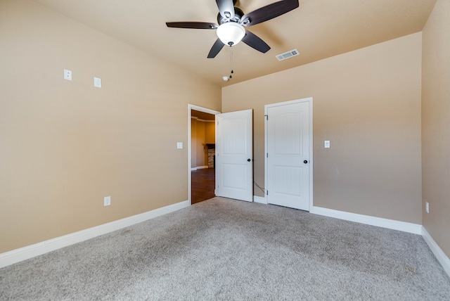 unfurnished bedroom featuring baseboards, visible vents, ceiling fan, and carpet