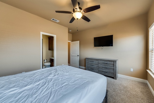 carpeted bedroom with baseboards, visible vents, ceiling fan, and ensuite bathroom