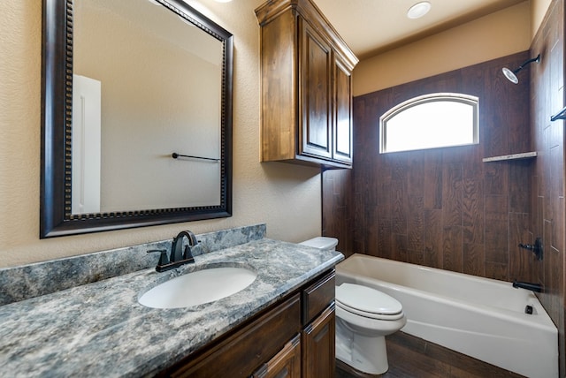 full bathroom with vanity, toilet, a textured wall, shower / tub combination, and wood finished floors
