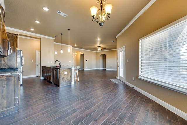kitchen with a sink, open floor plan, stainless steel appliances, visible vents, and arched walkways