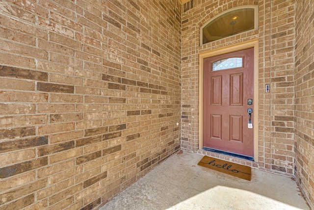 doorway to property featuring brick siding