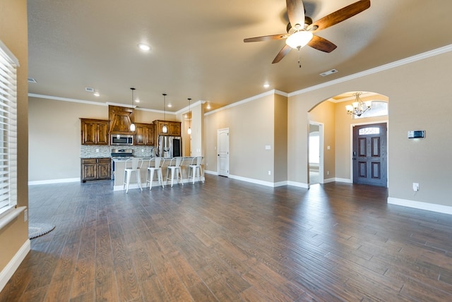 unfurnished living room with arched walkways, dark wood-style floors, visible vents, and ceiling fan with notable chandelier