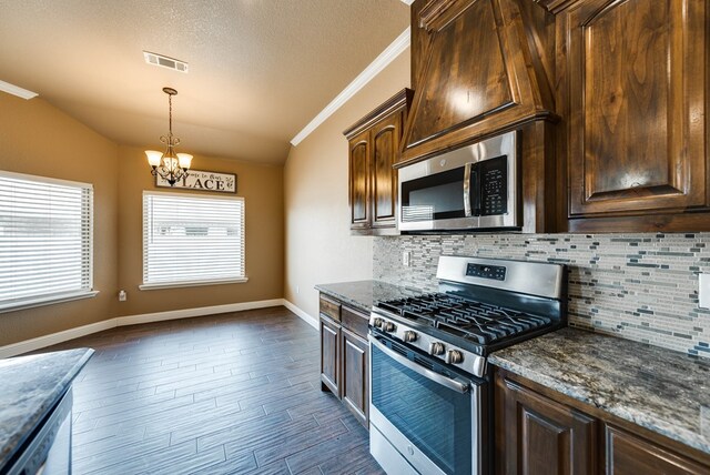 kitchen with lofted ceiling, an inviting chandelier, stainless steel appliances, visible vents, and dark brown cabinetry