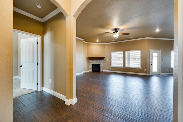 unfurnished living room featuring baseboards, ceiling fan, ornamental molding, and dark wood-style flooring