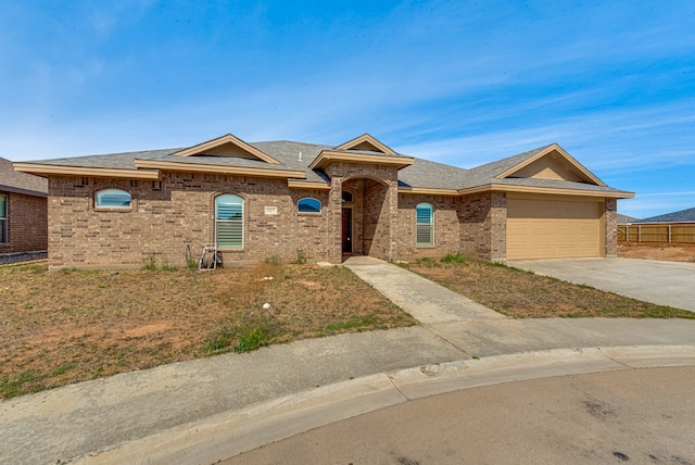 ranch-style home featuring brick siding, a garage, concrete driveway, and a shingled roof